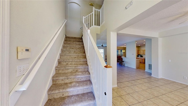 8520 La Isla Dr, Kissimmee, FL 34747 - staircase with tile patterned flooring and a textured ceiling