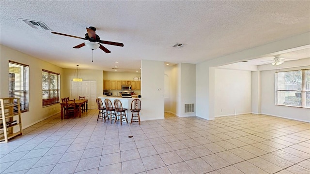 8520 La Isla Dr, Kissimmee, FL 34747 - living room with ceiling fan, light tile patterned floors, a textured ceiling, baseboards, and recessed lighting