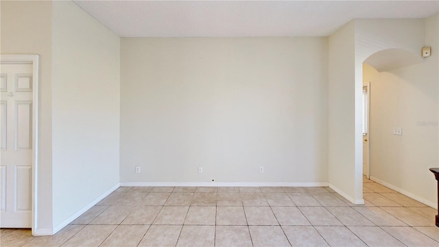 8520 La Isla Dr, Kissimmee, FL 34747 - unfurnished room featuring arched walkways, light tile patterned floors, and baseboards