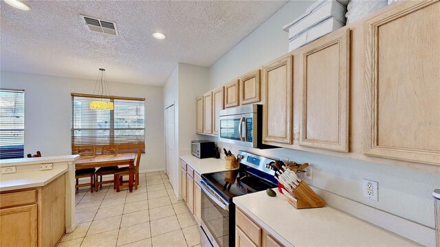 8520 La Isla Dr, Kissimmee, FL 34747 - kitchen featuring appliances with stainless steel finishes, light brown cabinets, light countertops, and a textured ceiling