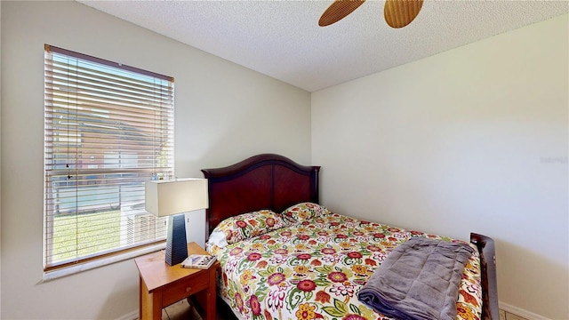 8520 La Isla Dr, Kissimmee, FL 34747 - bedroom with multiple windows, baseboards, ceiling fan, and a textured ceiling