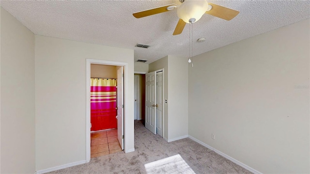 8520 La Isla Dr, Kissimmee, FL 34747 - unfurnished bedroom featuring carpet, a textured ceiling, ensuite bathroom, baseboards, and a ceiling fan