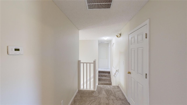 8520 La Isla Dr, Kissimmee, FL 34747 - hall featuring carpet floors, baseboards, an upstairs landing, and a textured ceiling