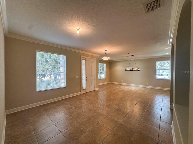 2585 Woodside Ridge Dr, Apopka, FL 32712 - empty room featuring healthy amount of natural light, ornamental molding, baseboards, a textured ceiling, and dark tile patterned flooring