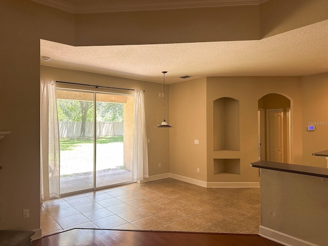 2585 Woodside Ridge Dr, Apopka, FL 32712 - tiled empty room with a textured ceiling, arched walkways, and baseboards
