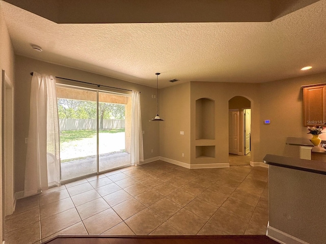 2585 Woodside Ridge Dr, Apopka, FL 32712 - empty room featuring arched walkways, light tile patterned flooring, a textured ceiling, baseboards, and recessed lighting