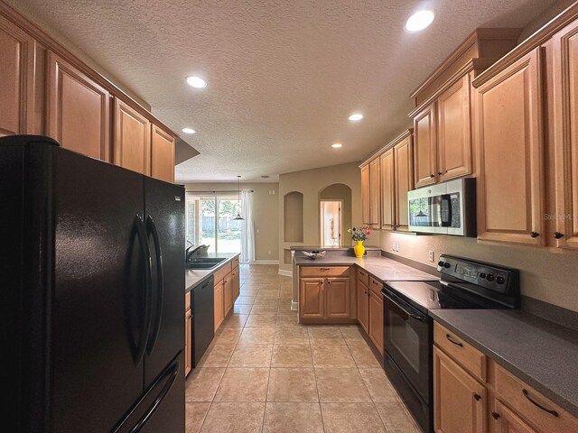 2585 Woodside Ridge Dr, Apopka, FL 32712 - kitchen featuring black appliances, arched walkways, a sink, recessed lighting, and a peninsula