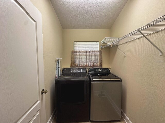 2585 Woodside Ridge Dr, Apopka, FL 32712 - washroom featuring washing machine and dryer, a textured ceiling, and baseboards
