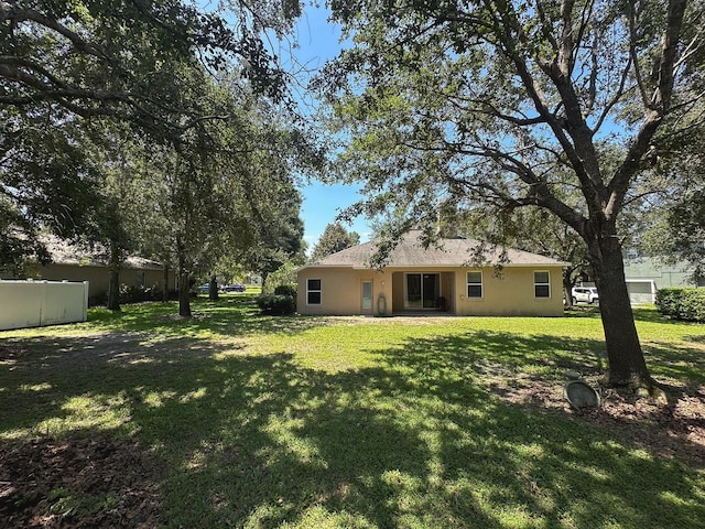 2585 Woodside Ridge Dr, Apopka, FL 32712 - rear view of house featuring a lawn and stucco siding