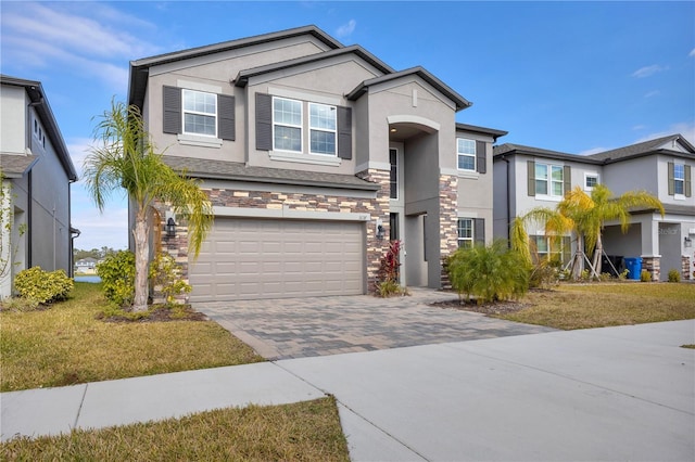 3137 Marine Grass Dr, Wimauma, FL 33598 - view of front of property with stucco siding, stone siding, an attached garage, driveway, and a front yard