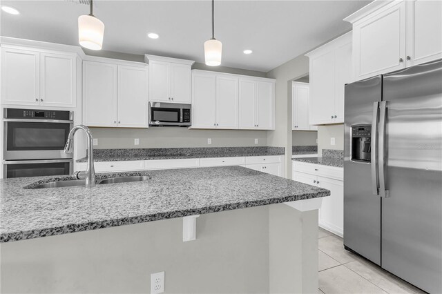 3137 Marine Grass Dr, Wimauma, FL 33598 - kitchen with appliances with stainless steel finishes, a sink, white cabinets, decorative light fixtures, and stone countertops