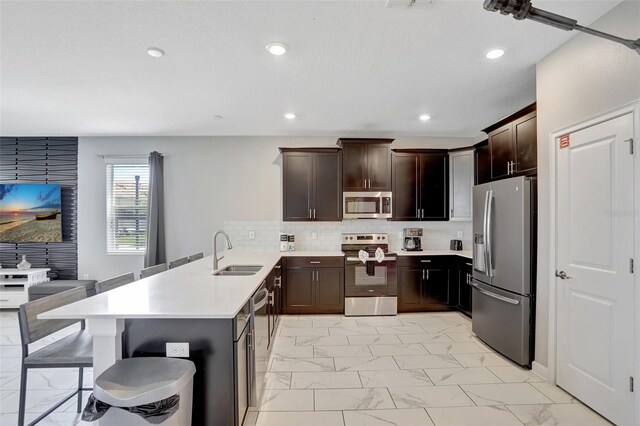 1533 Flange Dr, Davenport, FL 33896 - kitchen with appliances with stainless steel finishes, light marble finish flooring, a peninsula, a sink, and light countertops