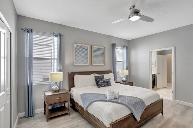 1533 Flange Dr, Davenport, FL 33896 - bedroom featuring light wood-style floors, baseboards, ensuite bathroom, and a ceiling fan