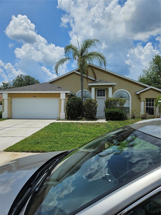 1710 Canoe Creek Rd, Oviedo, FL 32766 - single story home with stucco siding, a garage, concrete driveway, and a front yard