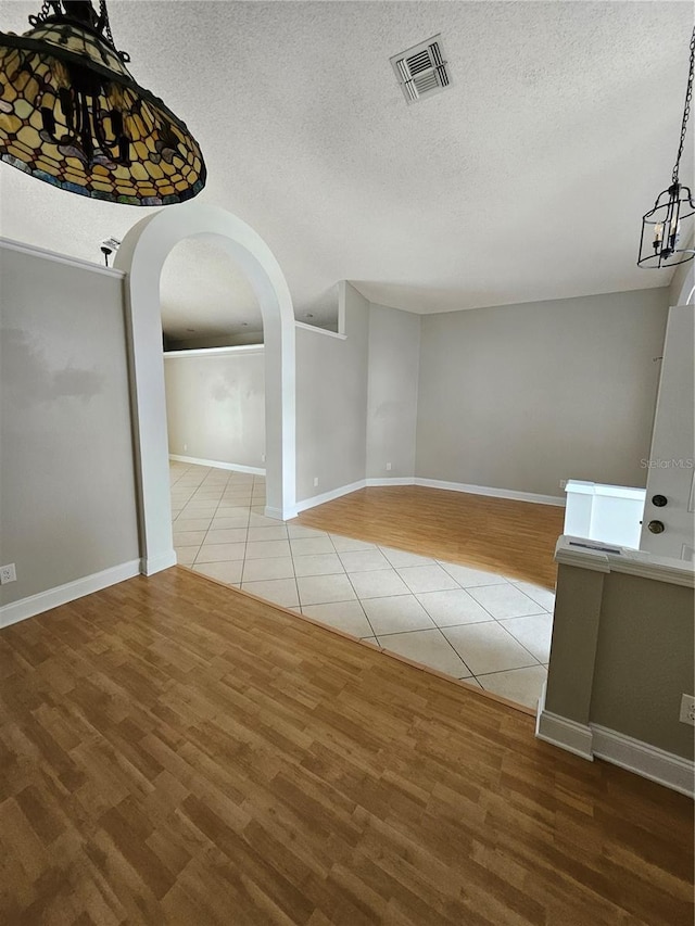 1710 Canoe Creek Rd, Oviedo, FL 32766 - unfurnished dining area with tile patterned floors, a textured ceiling, arched walkways, and baseboards