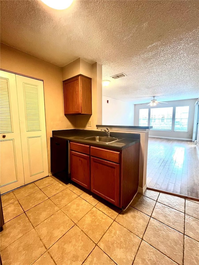 1057 S Hiawassee Rd Unit 1913, Orlando, FL 32835 - kitchen featuring a sink, dark countertops, a textured ceiling, a peninsula, and ceiling fan