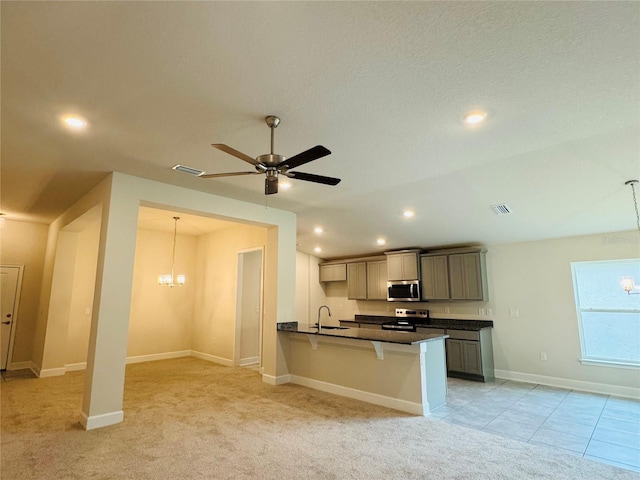 4326 Sagefield Dr, Harmony, FL 34773 - kitchen featuring a chandelier, a sink, dark countertops, stainless steel appliances, and a breakfast bar