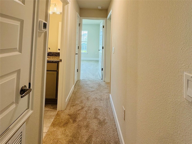 4326 Sagefield Dr, Harmony, FL 34773 - hall with light carpet, a textured wall, and baseboards
