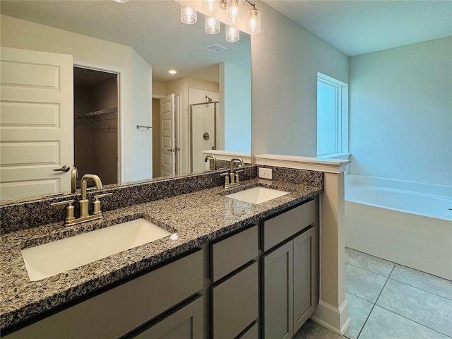 4326 Sagefield Dr, Harmony, FL 34773 - full bath featuring a stall shower, double vanity, a spacious closet, tile patterned floors, and a bath