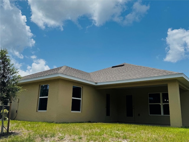 4326 Sagefield Dr, Harmony, FL 34773 - rear view of property featuring stucco siding, a lawn, and a shingled roof