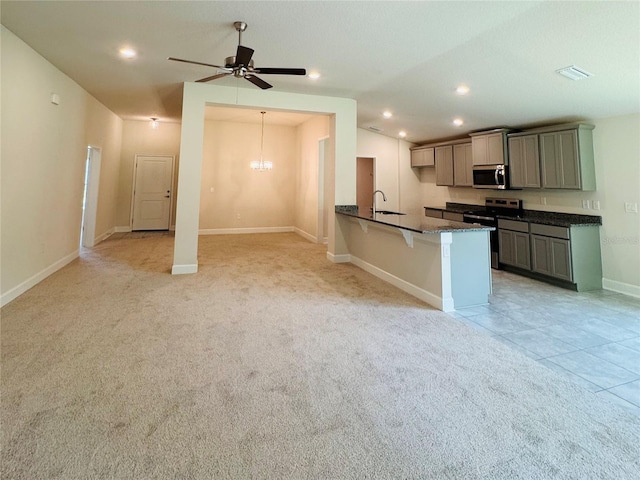 4326 Sagefield Dr, Harmony, FL 34773 - kitchen with appliances with stainless steel finishes, a kitchen bar, light carpet, ceiling fan, and recessed lighting
