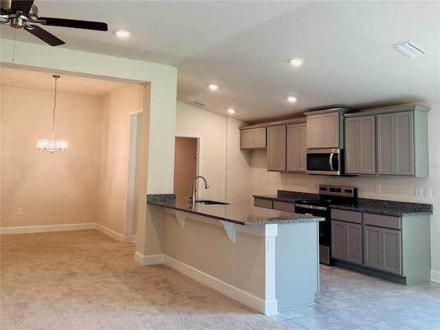 4326 Sagefield Dr, Harmony, FL 34773 - kitchen with appliances with stainless steel finishes, gray cabinets, a kitchen breakfast bar, dark stone countertops, and recessed lighting