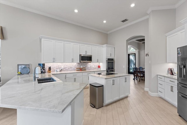 2046 Westover Reserve Blvd, Windermere, FL 34786 - kitchen with a sink, stainless steel microwave, arched walkways, refrigerator with ice dispenser, and a peninsula