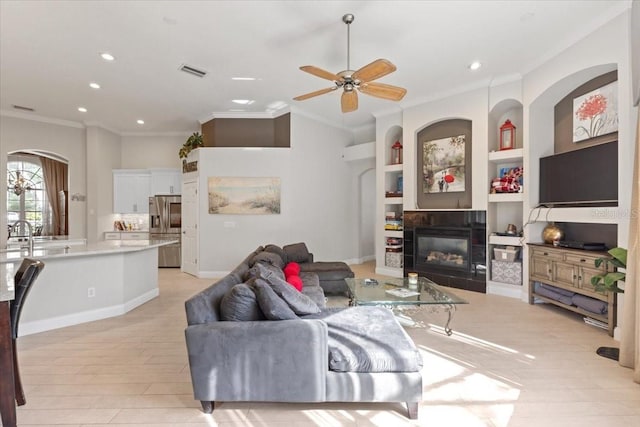 2046 Westover Reserve Blvd, Windermere, FL 34786 - living room featuring ornamental molding, a ceiling fan, a fireplace, recessed lighting, and built in features