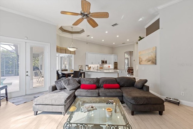 2046 Westover Reserve Blvd, Windermere, FL 34786 - living area with light wood-type flooring, arched walkways, ornamental molding, ceiling fan, and french doors