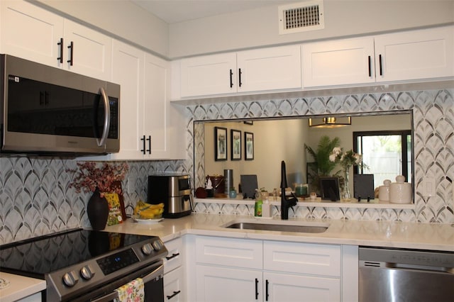 3044 S Oakland Forest Dr Unit 2403, Oakland Park, FL 33309 - kitchen featuring stainless steel appliances, a sink, light countertops, white cabinetry, and backsplash