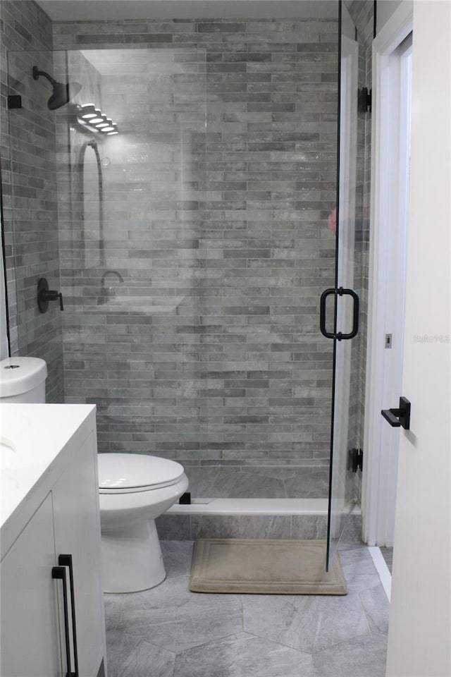 3044 S Oakland Forest Dr Unit 2403, Oakland Park, FL 33309 - full bathroom with toilet, a stall shower, vanity, and tile walls