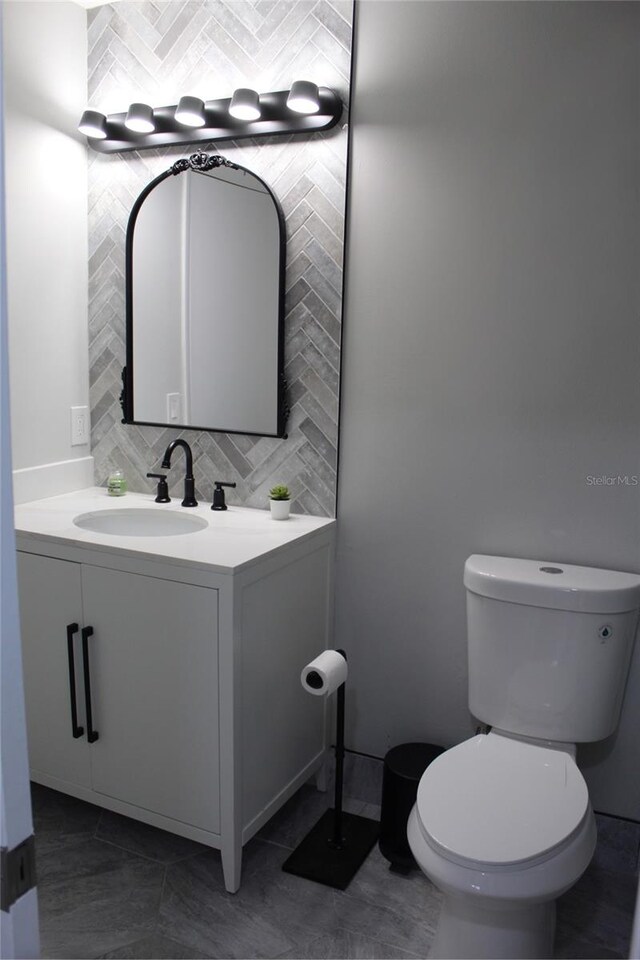 3044 S Oakland Forest Dr Unit 2403, Oakland Park, FL 33309 - half bath with backsplash, vanity, toilet, and tile patterned flooring