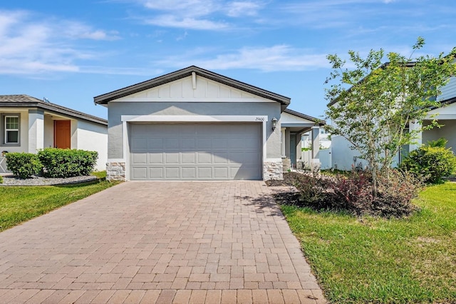 29400 Caspian St, Leesburg, FL 34748 - ranch-style house with stone siding, decorative driveway, a garage, board and batten siding, and stucco siding
