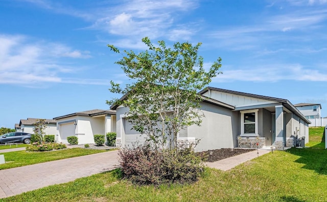 29400 Caspian St, Leesburg, FL 34748 - view of front of property featuring an attached garage, a front yard, driveway, stucco siding, and board and batten siding