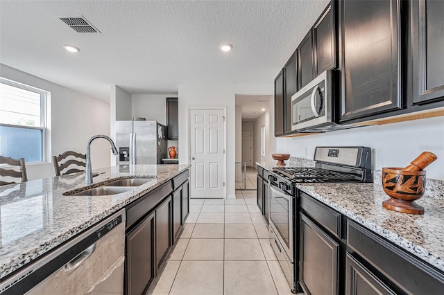 29400 Caspian St, Leesburg, FL 34748 - kitchen featuring stainless steel appliances, a sink, light stone counters, light tile patterned floors, and recessed lighting