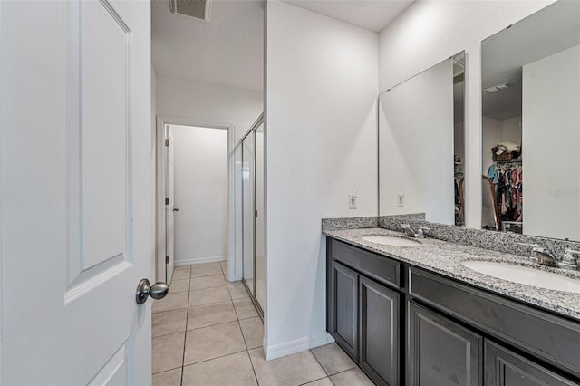 29400 Caspian St, Leesburg, FL 34748 - full bath featuring a walk in closet, double vanity, a stall shower, tile patterned flooring, and baseboards