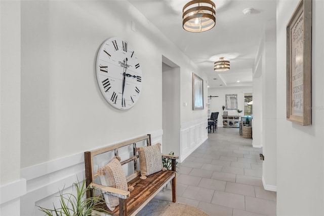 10815 Laxer Cay Loop, San Antonio, FL 33576 - hall featuring tile patterned floors, a wainscoted wall, and a decorative wall