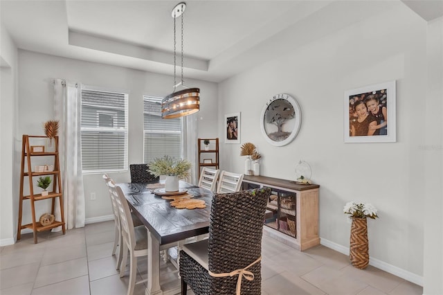 10815 Laxer Cay Loop, San Antonio, FL 33576 - dining area featuring baseboards, light tile patterned floors, and a tray ceiling