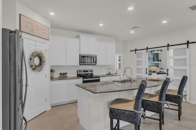 10815 Laxer Cay Loop, San Antonio, FL 33576 - kitchen with appliances with stainless steel finishes, a sink, a kitchen bar, stone countertops, and white cabinetry