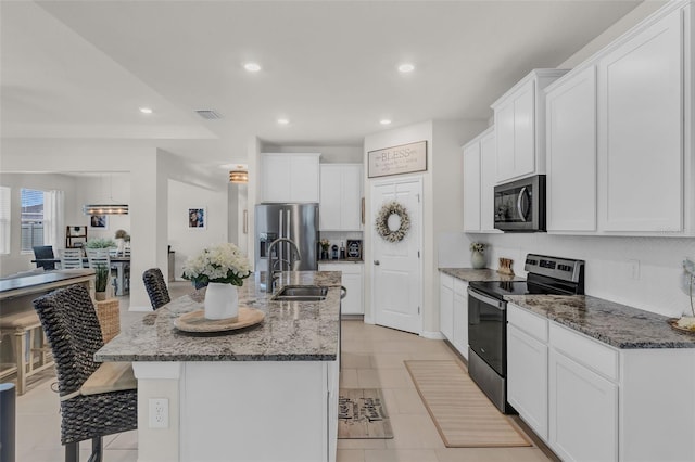 10815 Laxer Cay Loop, San Antonio, FL 33576 - kitchen featuring stainless steel appliances, a sink, recessed lighting, white cabinets, and an island with sink