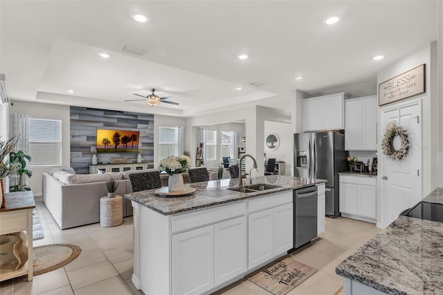 10815 Laxer Cay Loop, San Antonio, FL 33576 - kitchen featuring a sink, stainless steel appliances, ceiling fan, a kitchen island with sink, and a raised ceiling