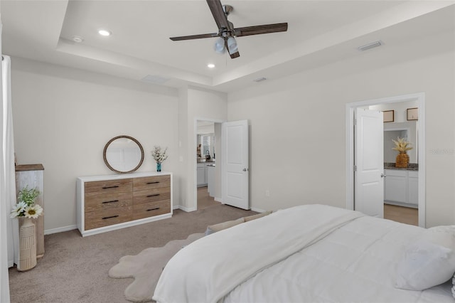 10815 Laxer Cay Loop, San Antonio, FL 33576 - bedroom featuring recessed lighting, a tray ceiling, baseboards, light colored carpet, and ensuite bathroom