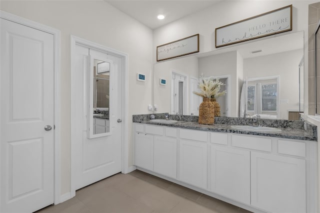 10815 Laxer Cay Loop, San Antonio, FL 33576 - bathroom with double vanity, tile patterned floors, and baseboards