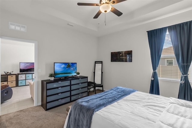 10815 Laxer Cay Loop, San Antonio, FL 33576 - carpeted bedroom with a raised ceiling, tile patterned floors, and ceiling fan