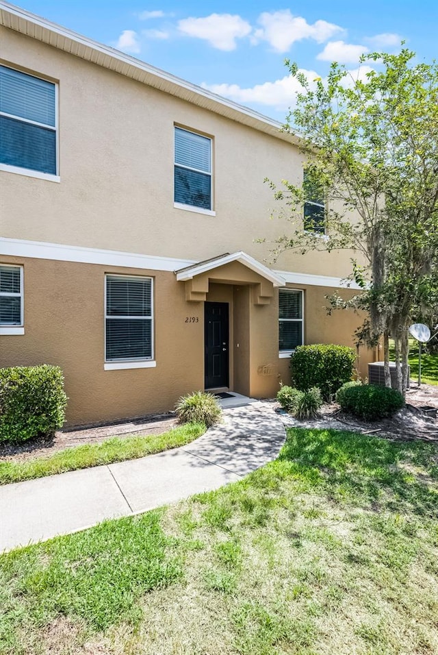 2193 Betsy Ross Ln, Saint Cloud, FL 34769 - townhome / multi-family property with stucco siding, a front yard, and cooling unit