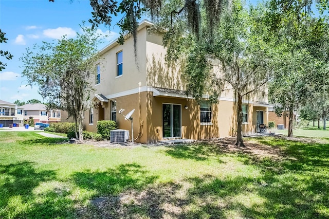 2193 Betsy Ross Ln, Saint Cloud, FL 34769 - back of house with stucco siding, central air condition unit, and a yard