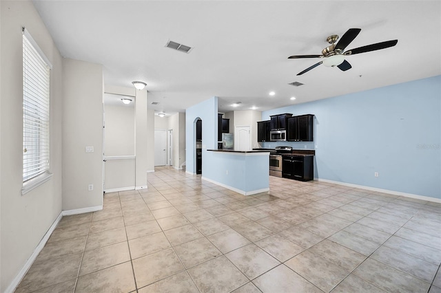 2193 Betsy Ross Ln, Saint Cloud, FL 34769 - kitchen with appliances with stainless steel finishes, open floor plan, dark cabinetry, dark countertops, and light tile patterned floors