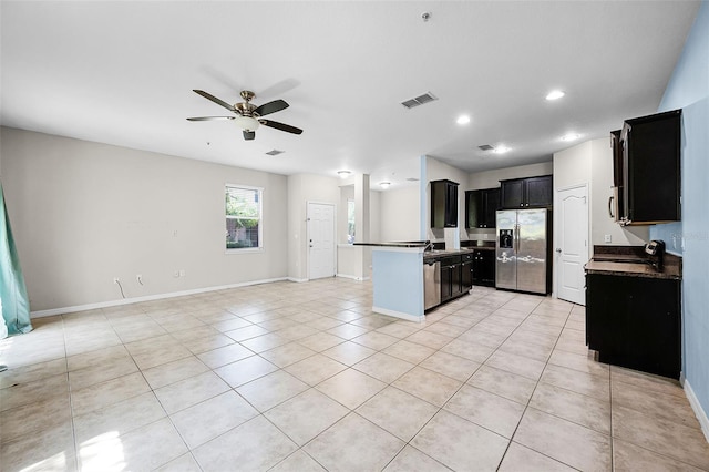 2193 Betsy Ross Ln, Saint Cloud, FL 34769 - kitchen with stainless steel fridge, open floor plan, dark cabinets, a ceiling fan, and light tile patterned floors