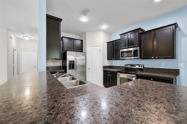 2193 Betsy Ross Ln, Saint Cloud, FL 34769 - kitchen featuring stainless steel appliances, a sink, dark countertops, recessed lighting, and a textured ceiling