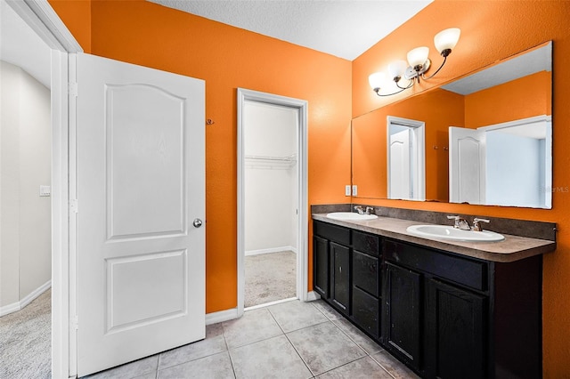 2193 Betsy Ross Ln, Saint Cloud, FL 34769 - bathroom featuring double vanity, tile patterned flooring, baseboards, and a spacious closet